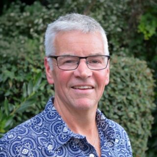 Local CAP worker representative, John, wearing a blue shirt and glasses, smiling at the camera