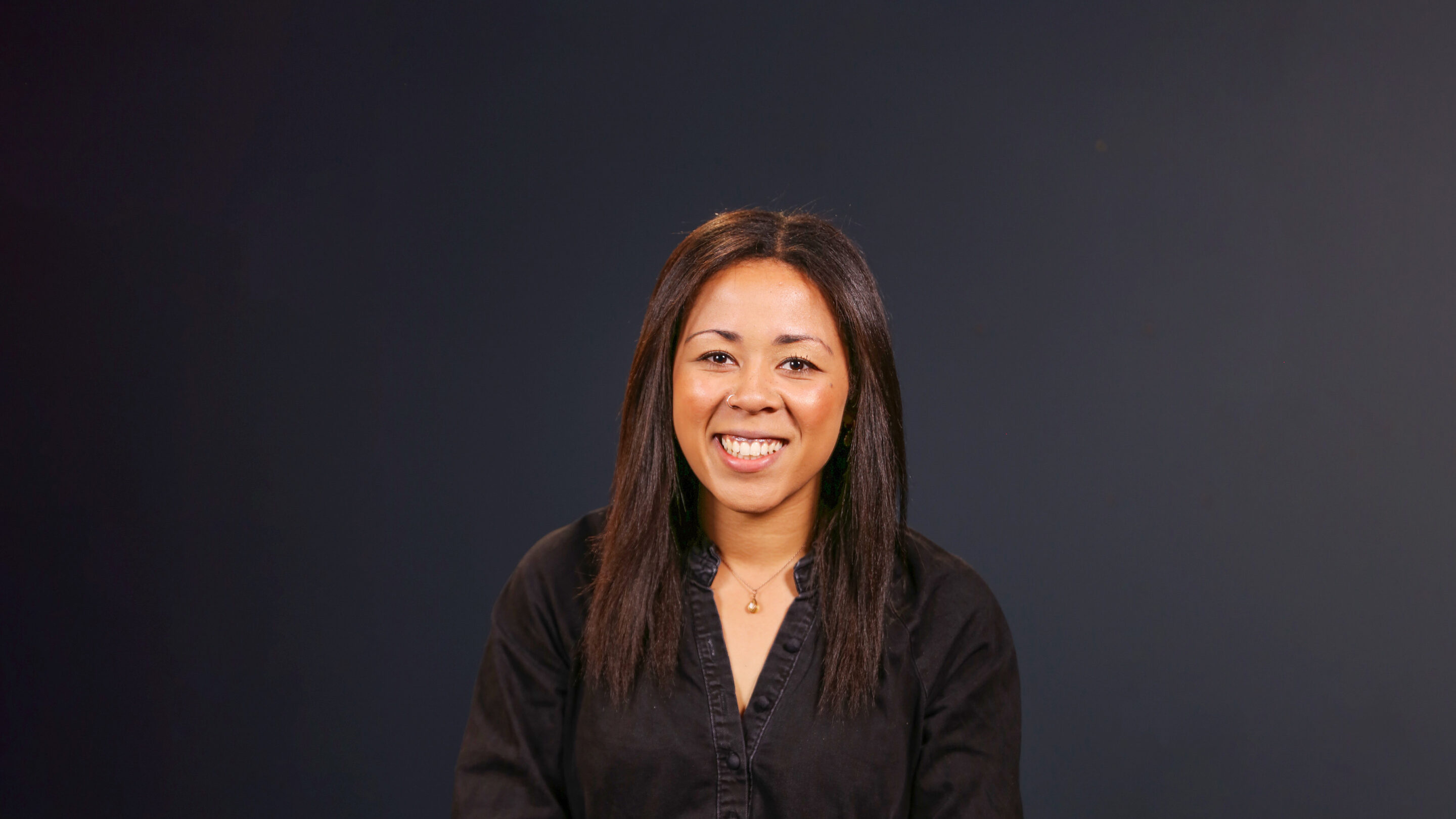 Young woman broadly smiling at camera.