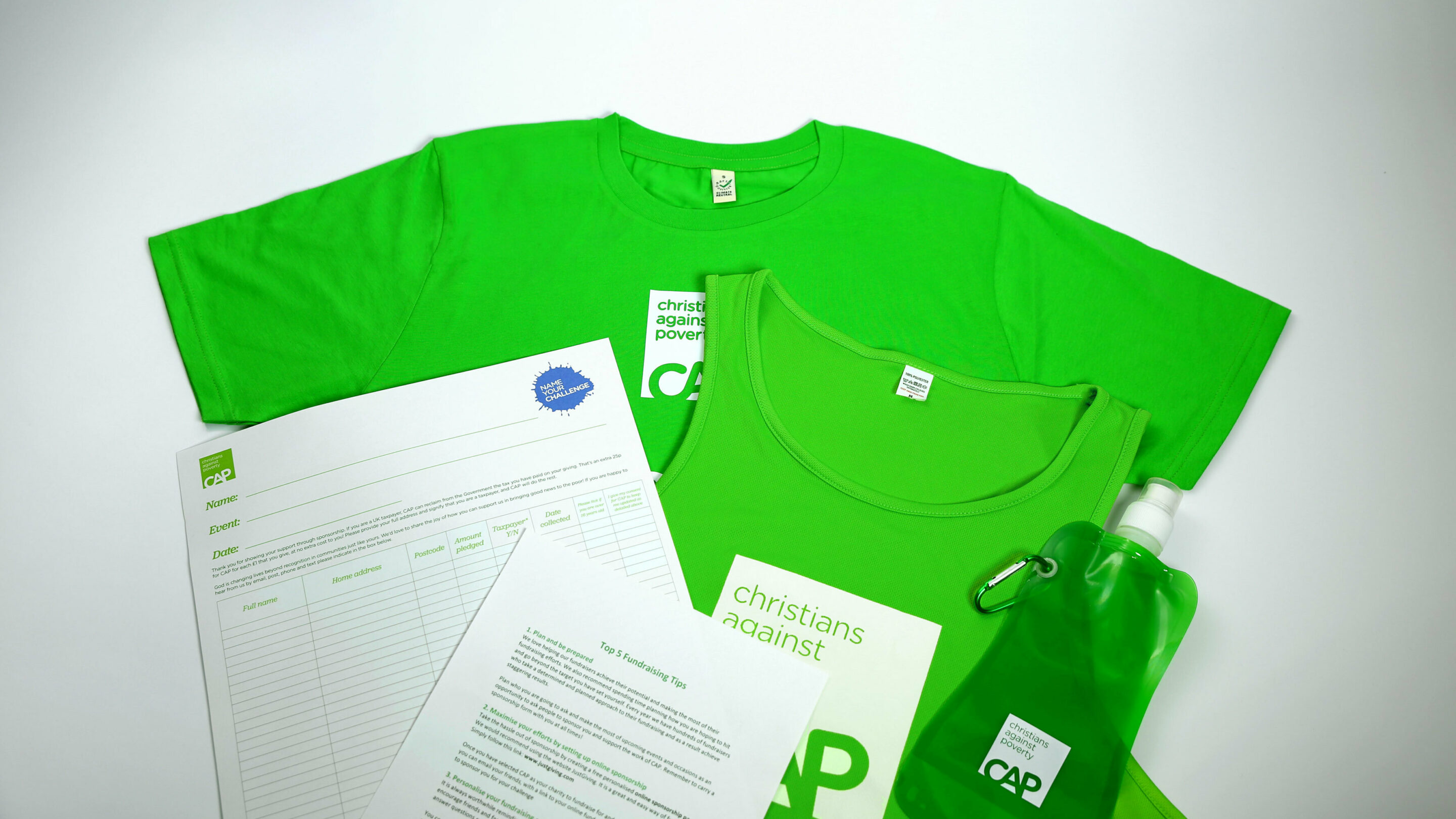 A green t shirt, running tank top, water bottle and paperwork