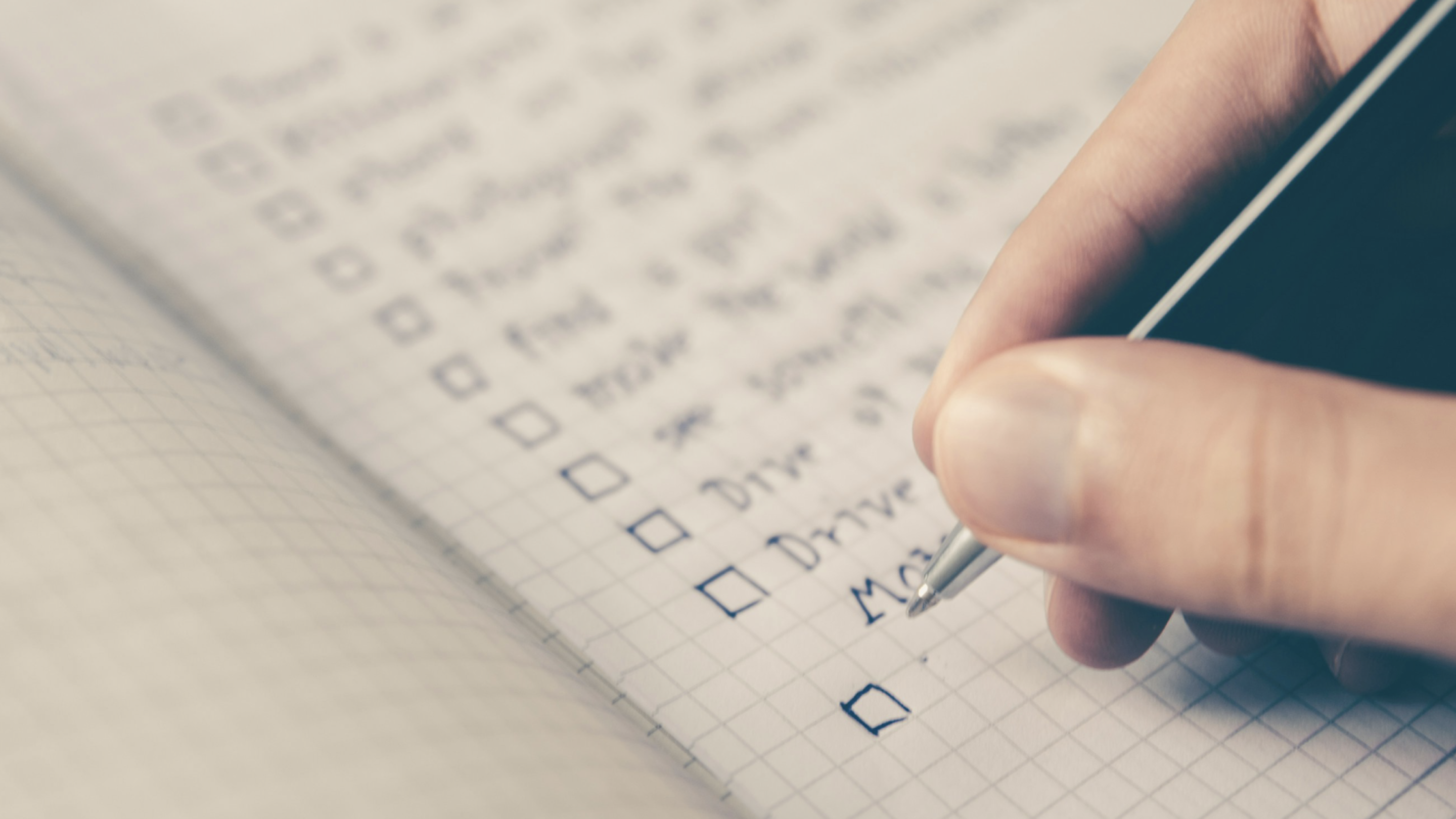 Image of a person writing a to-do list in a notebook