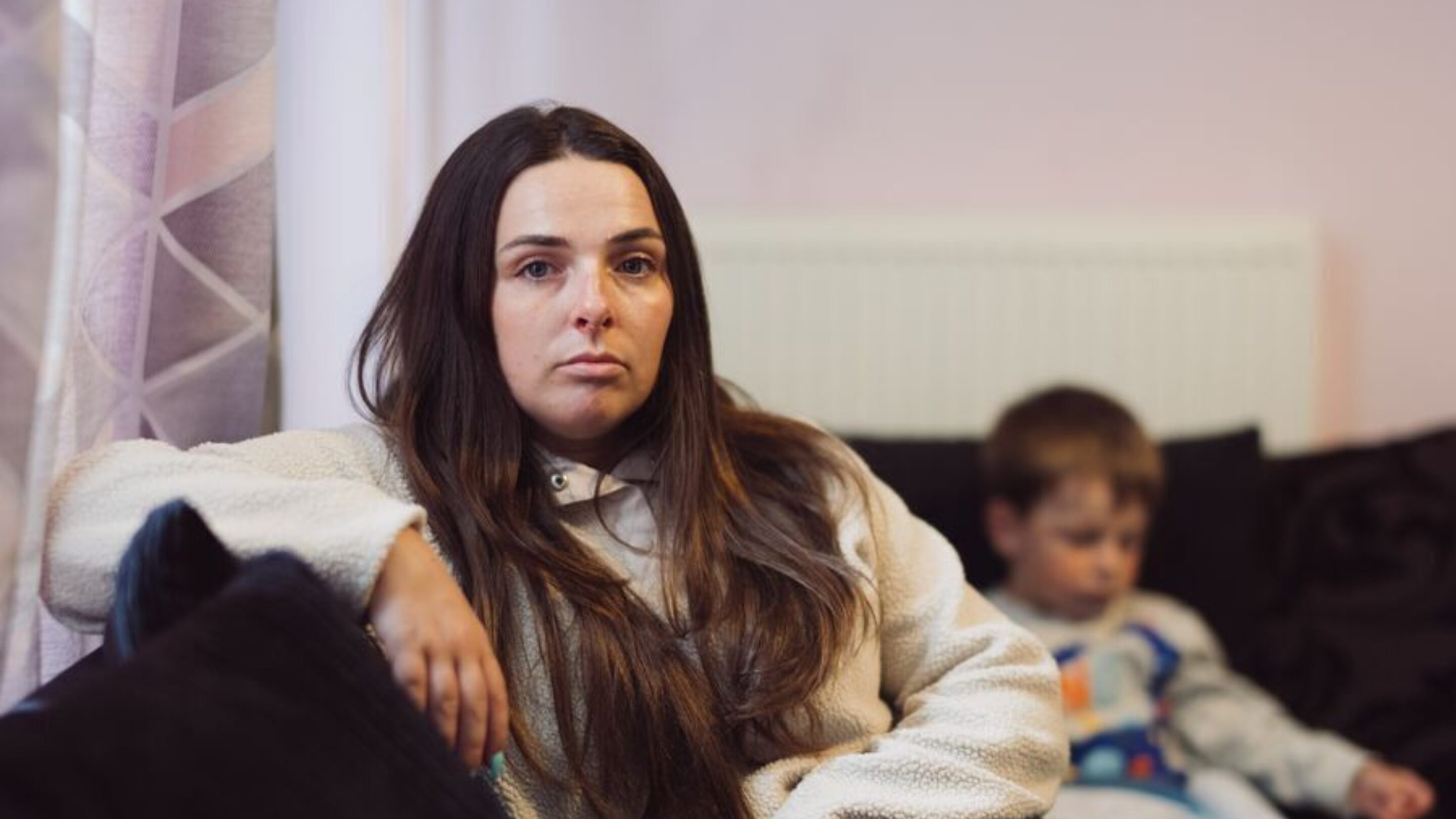 Client looks at camera from sofa