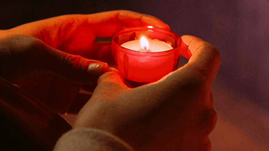 Hands holding a candle. Original photography by Anna Shvets.