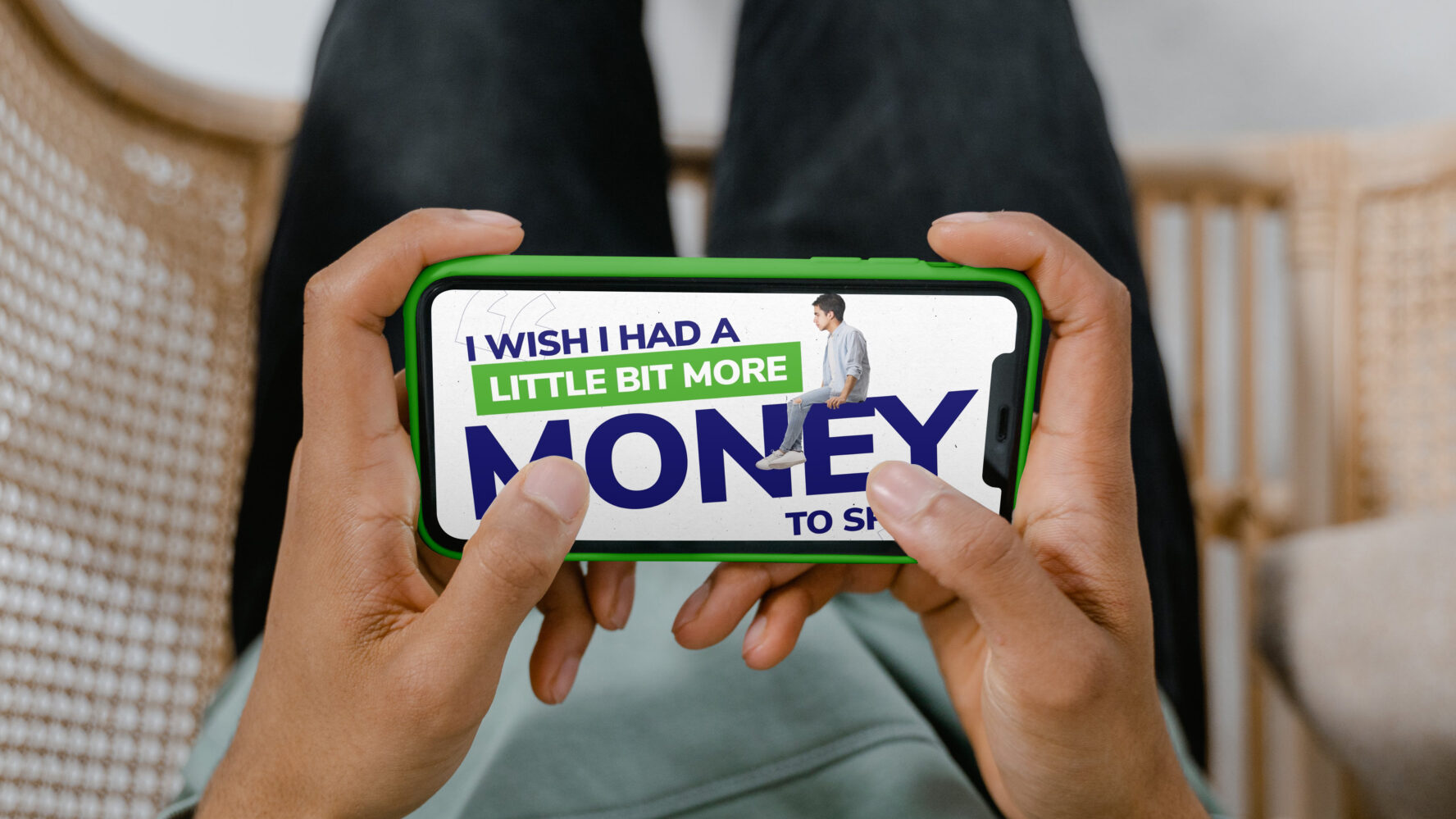 Looking down at a phone screen, tilted sideways and watching a video that says 'I wish I had a little bit more money to spare'