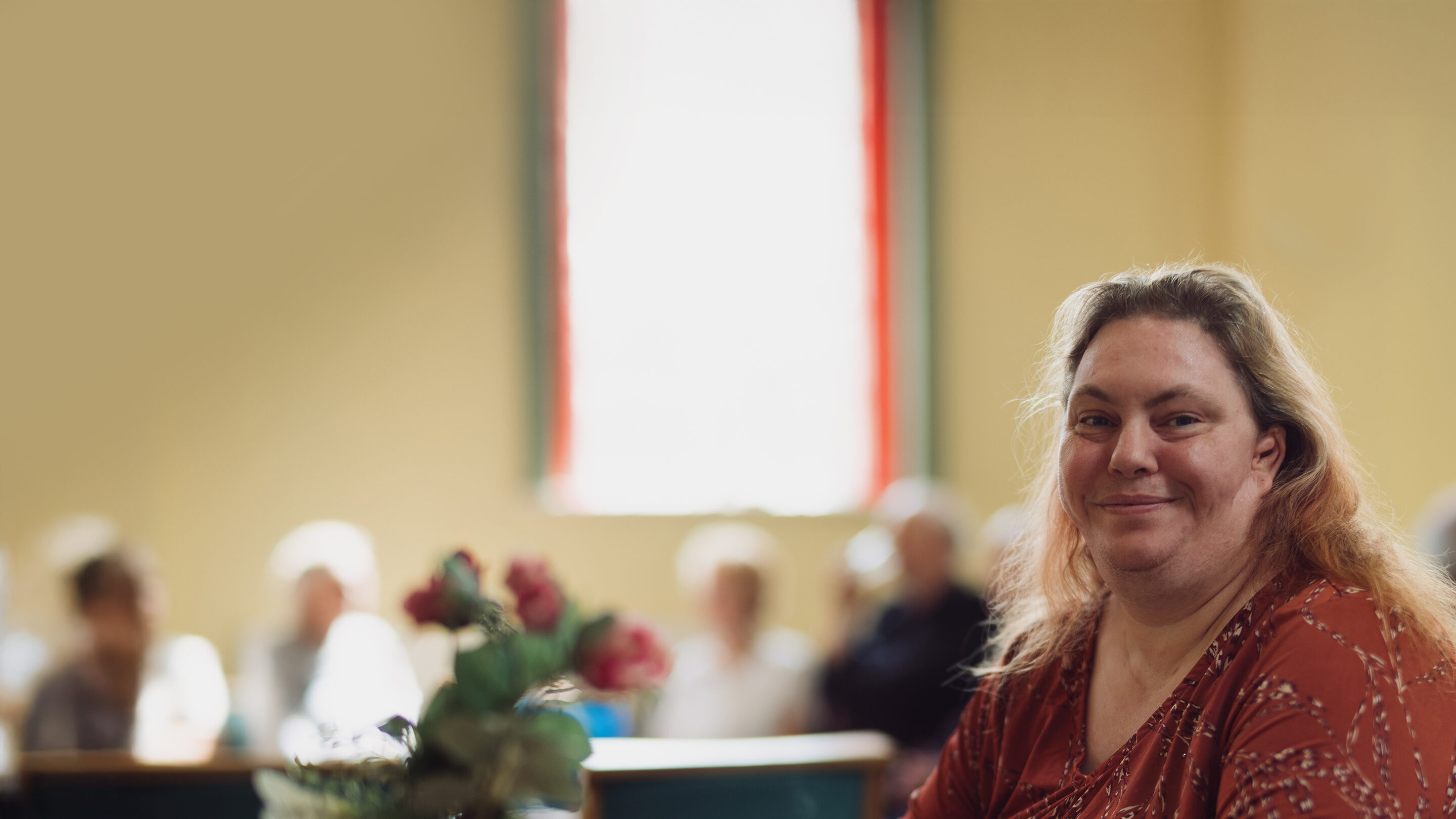 Woman in a red top smiling at camera