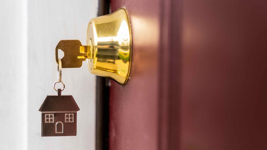 Key in front door with a house keyring.