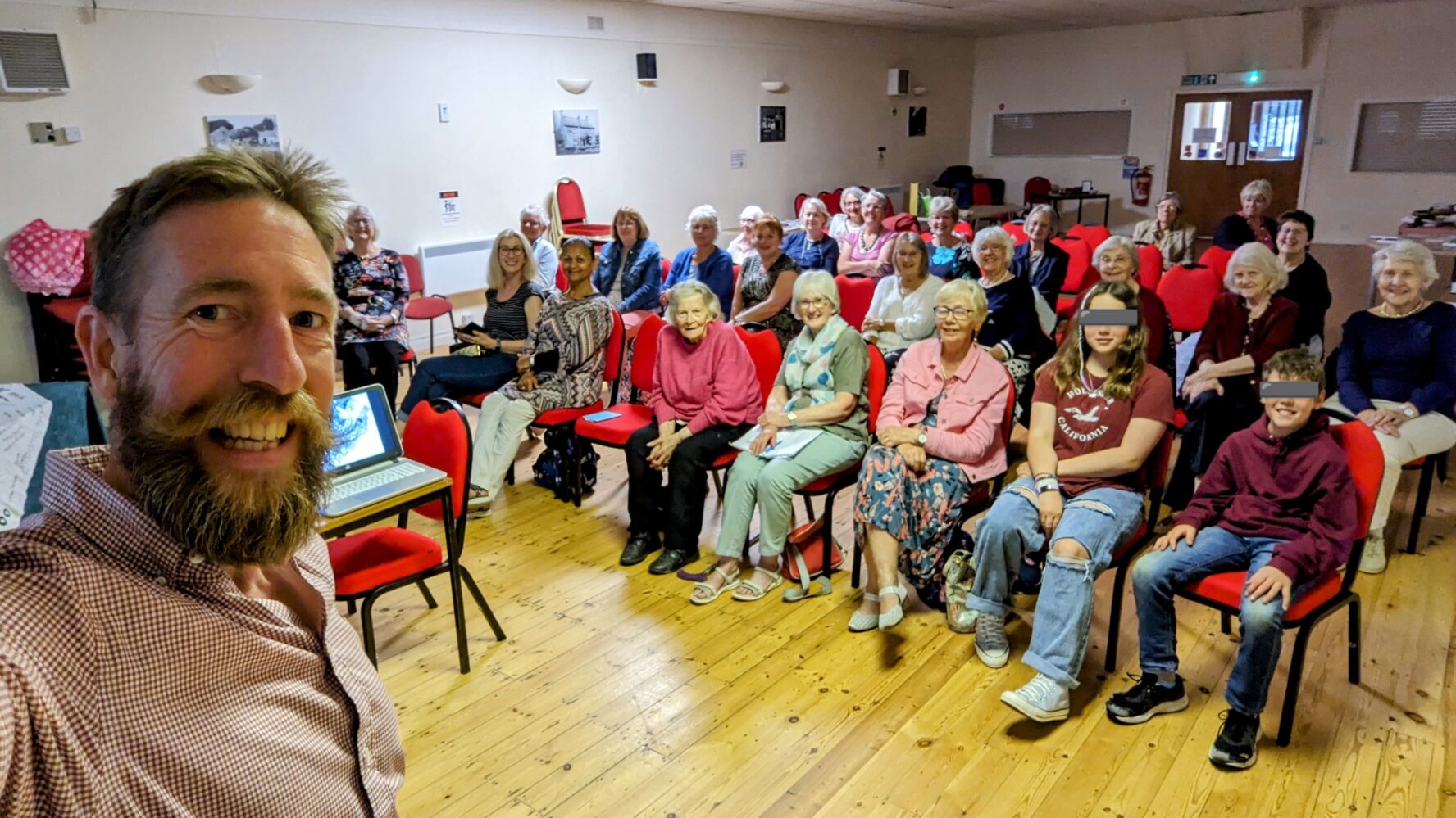 CAP supporter Jim, a while male with brown short hair and a beard, taking a selfie with the audience at one of his archeology talks