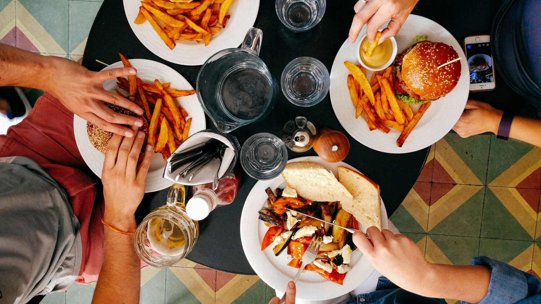Birds-eye image of four people eating burgers at a restaurant
