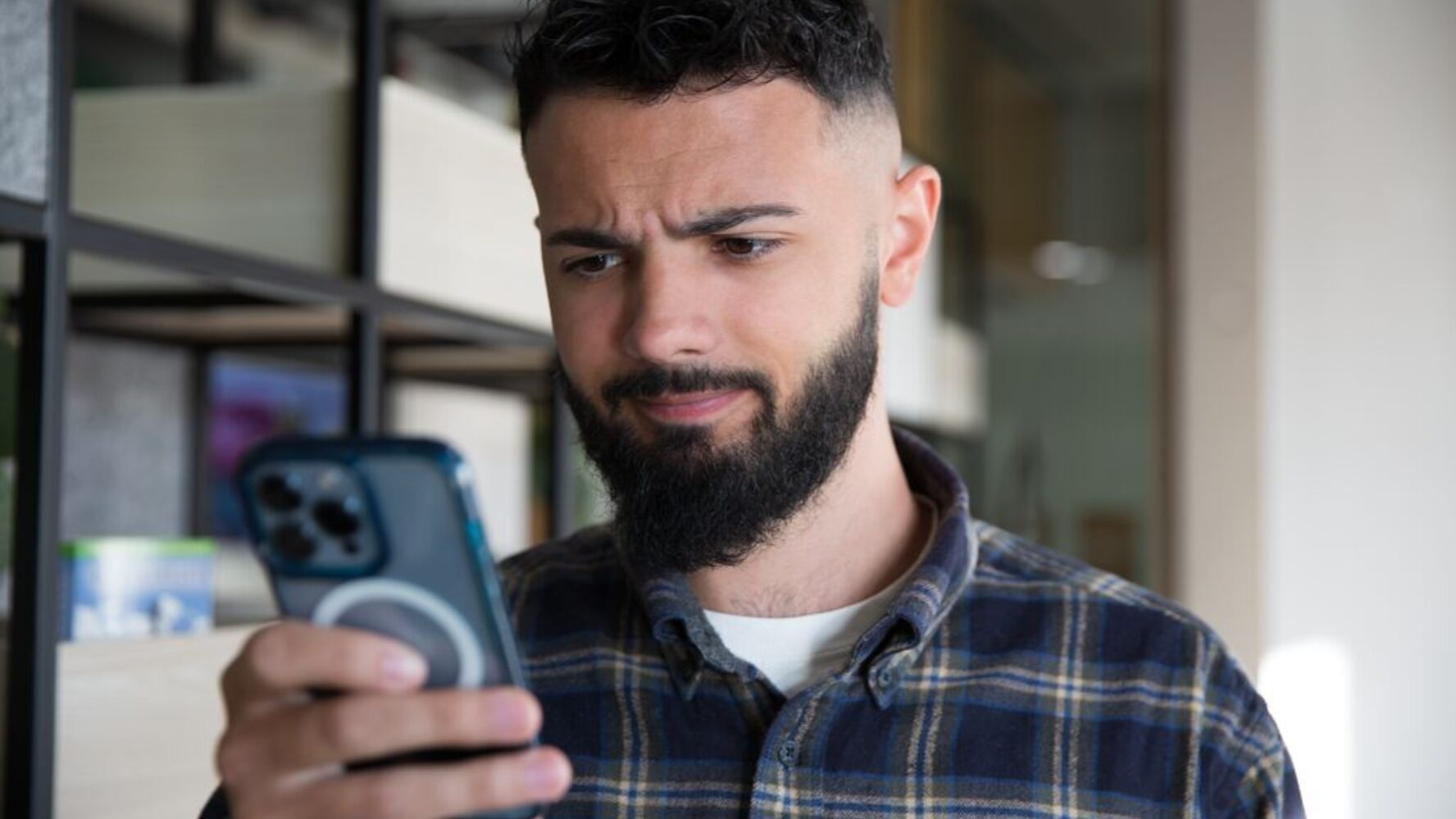 CAP staff member looking at his mobile phone with a confused expression