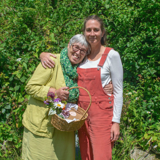 Debt Coach Melissa with her mum, who is holding a basket of flowers.