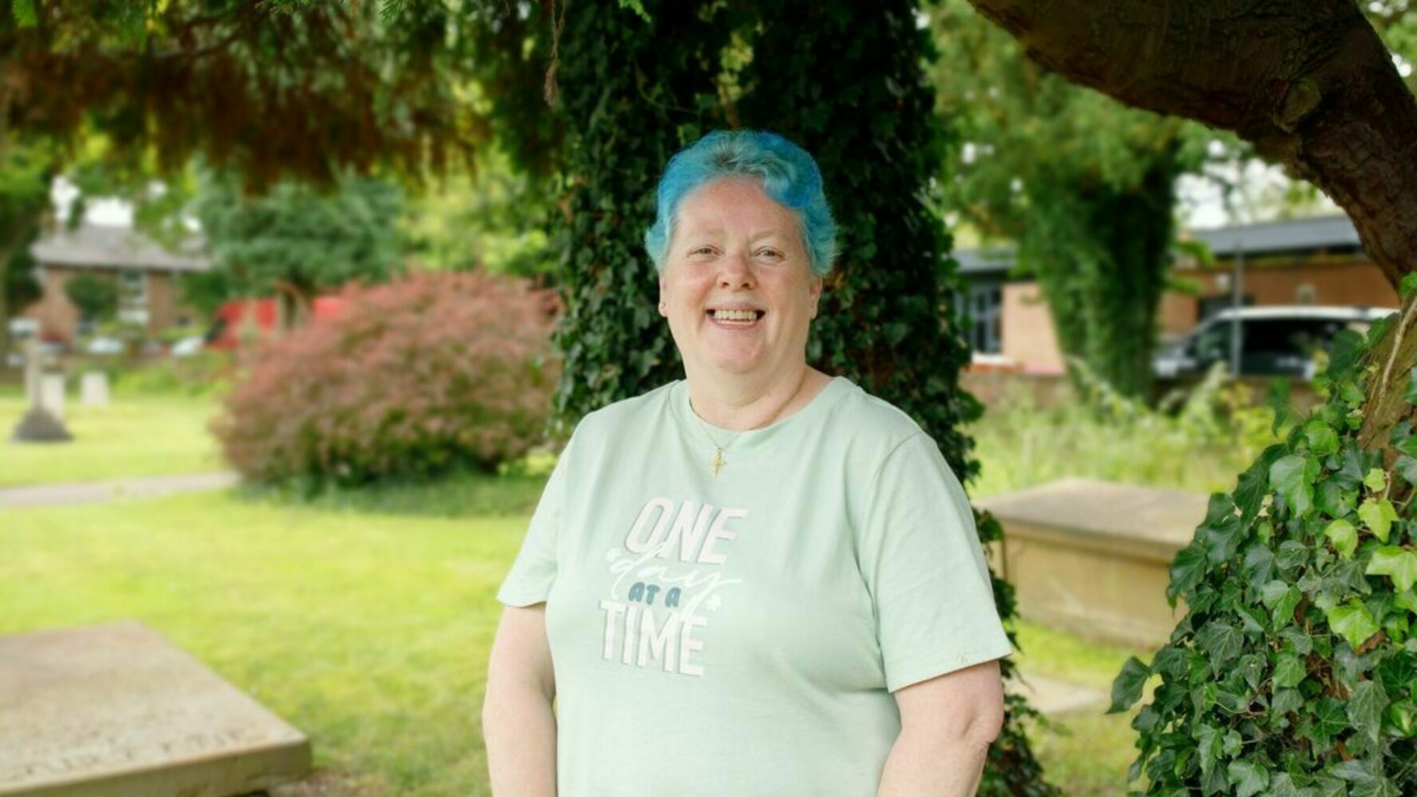 CAP client stood in front of a tree in a garden, smiling at the camera