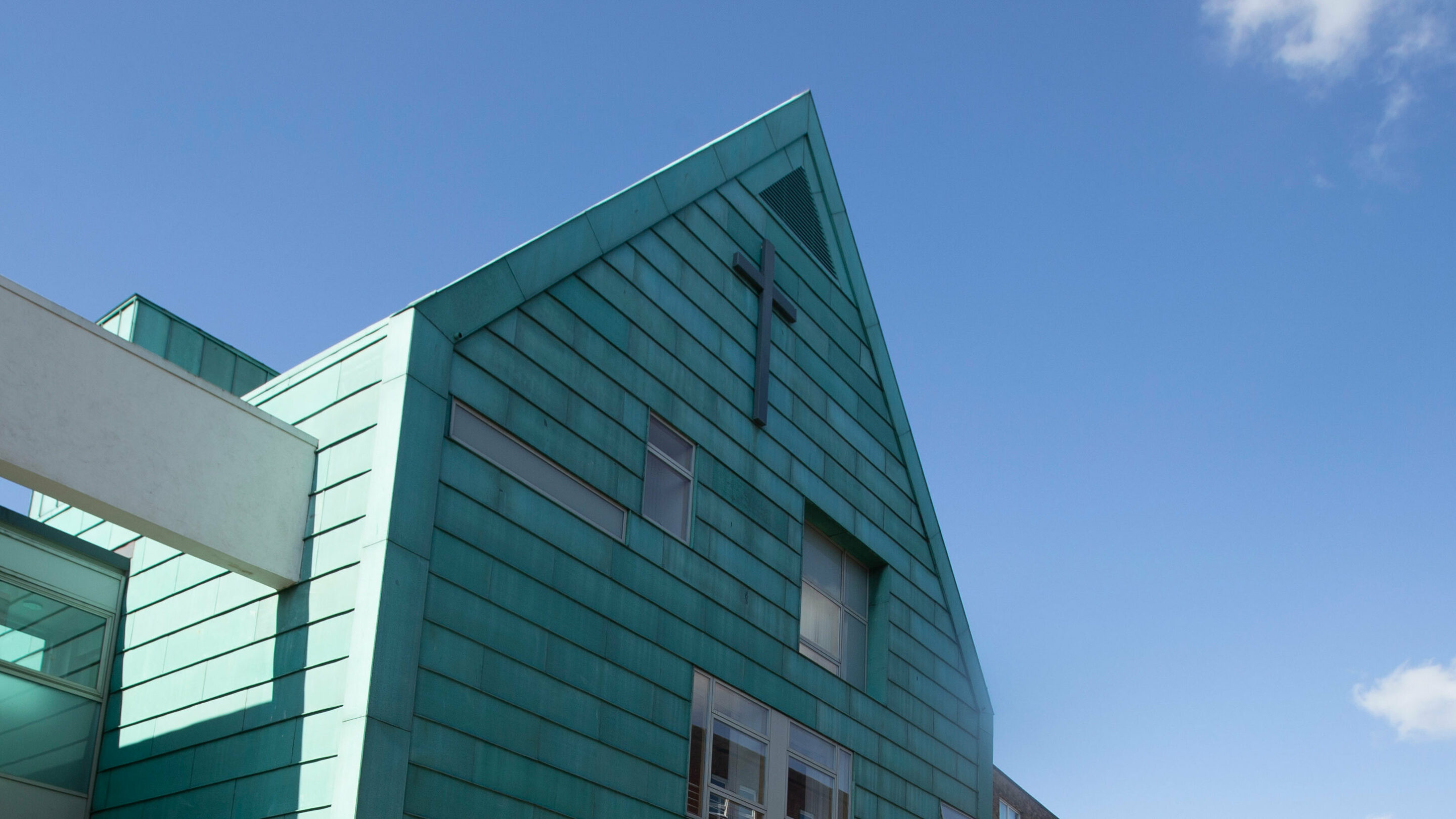 Blue church building with a cross at the top.