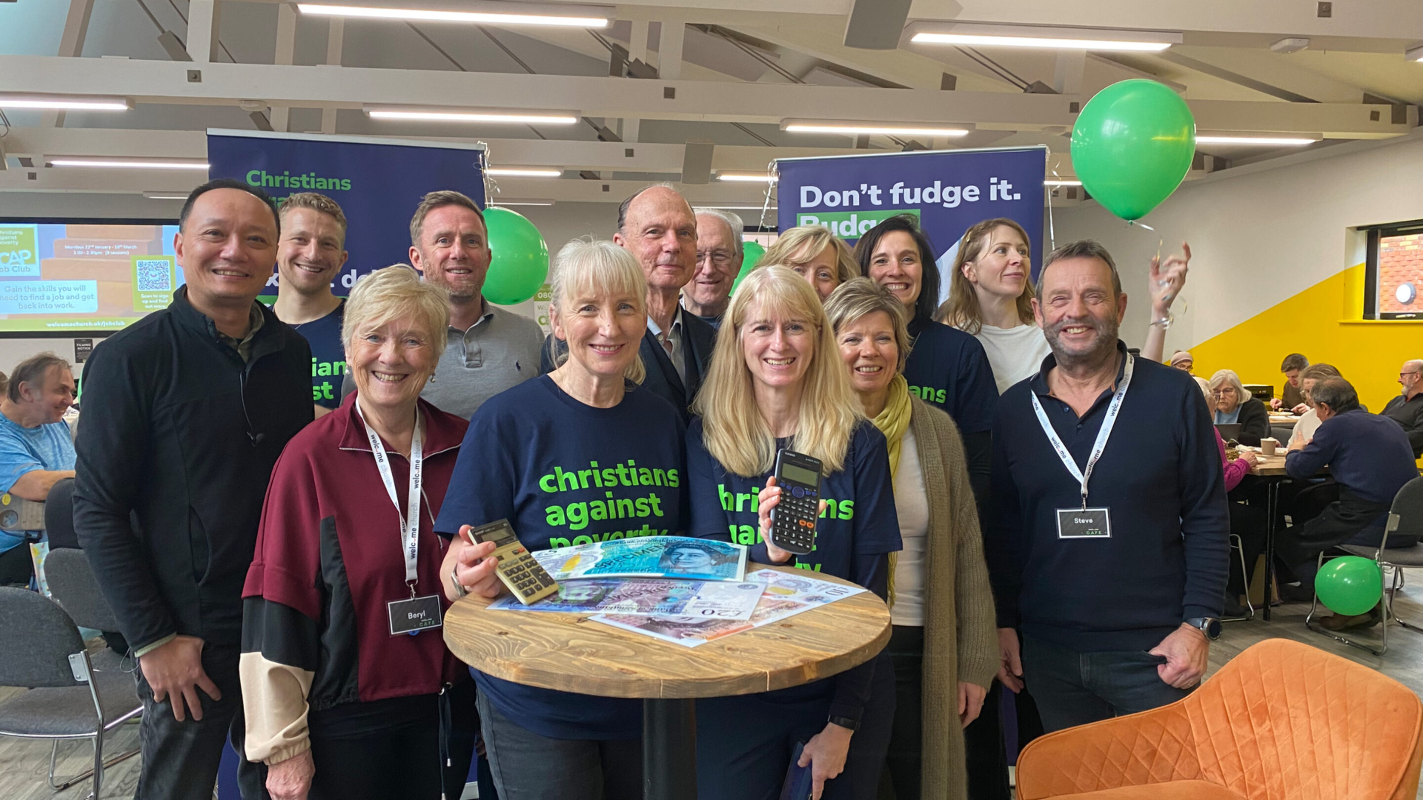 CAP staff at an event, stood in front of CAP banners and green balloons, smiling