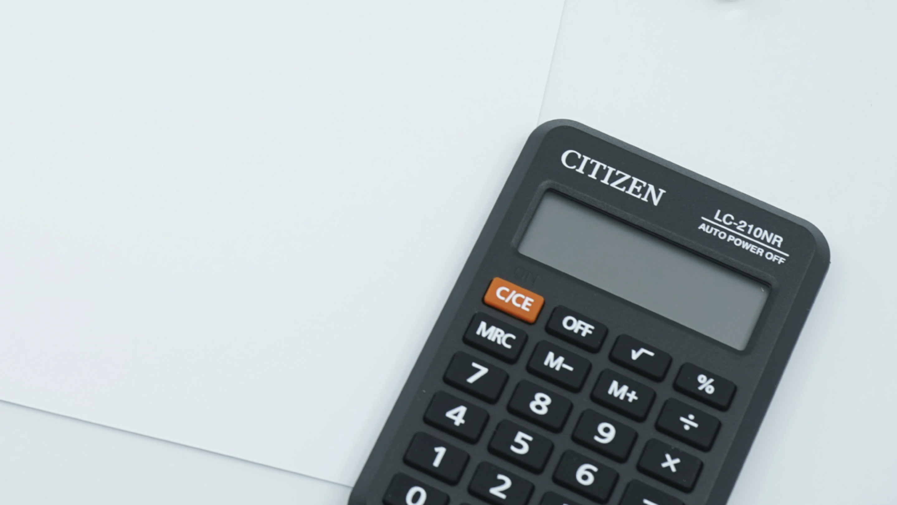 Photo of a calculator on a white desk