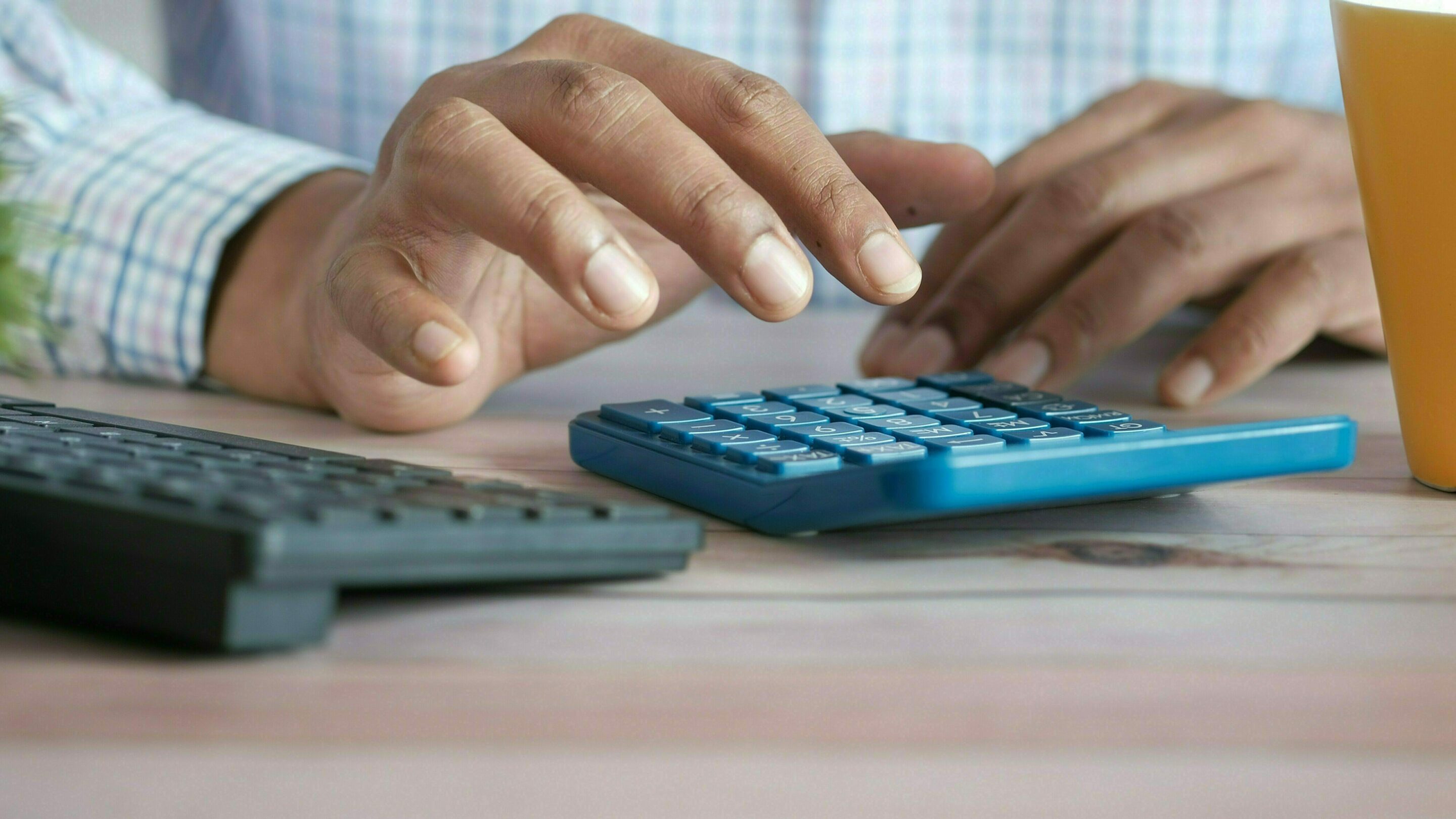 Person typing on a calculator