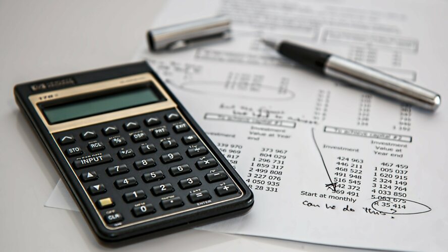 A pen and calculator show there is free help with your finances available