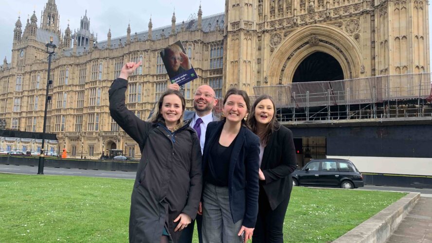 Social Policy Manager at CAP celebrates a policy win with the Policy and Research team outside the Houses of Parliament.
