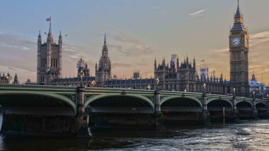 Westminster Bridge in London, big building behind the bridge, tower with a clock.