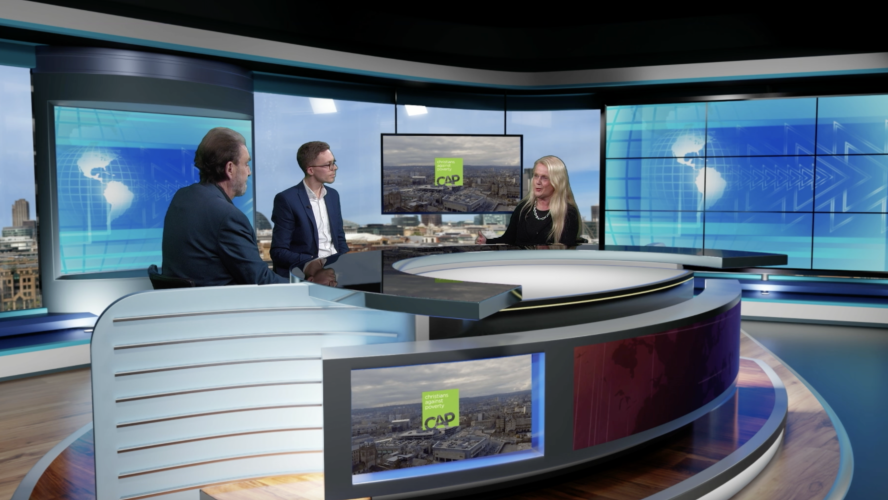 CAP staff at the Revelation TV studios being interviewed around a desk in front of a green screen.