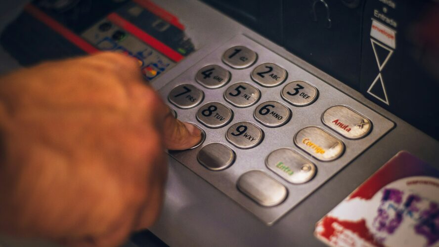 Person putting pin into cash machine