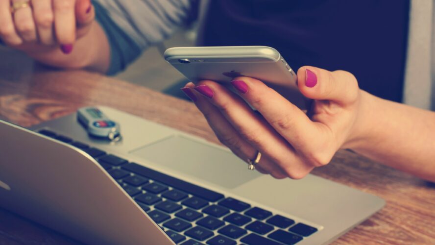 Laptop with someone holding their phone