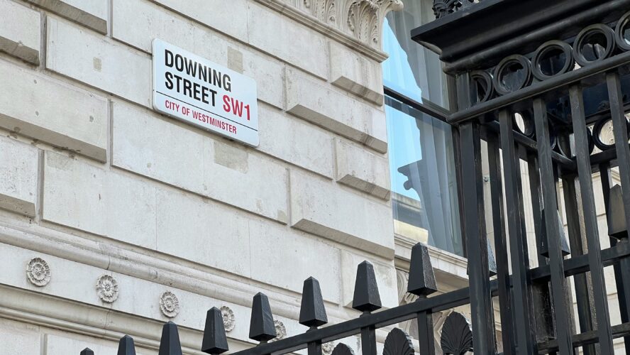 The side of the building at Downing Street with the street sign on it.
