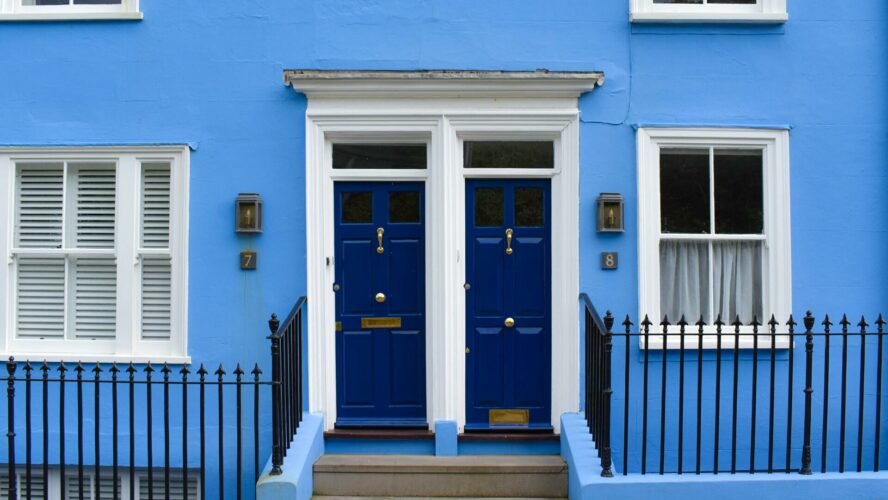 Two blue front doors with blue walls.