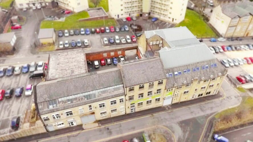 Bird's eye view of the old office building, carpark spaces surrounding it.