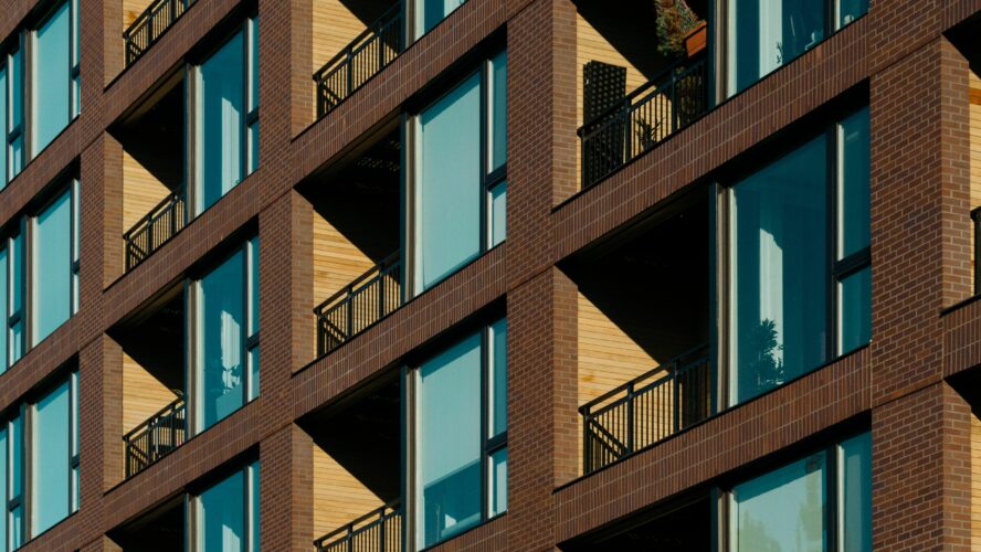 A block of modern flat with blue window glass and balconies.