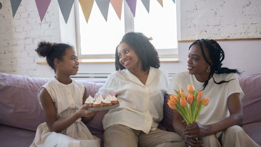 a mum with her two daughters, flowers and cupcakes celebrating Mother's day.