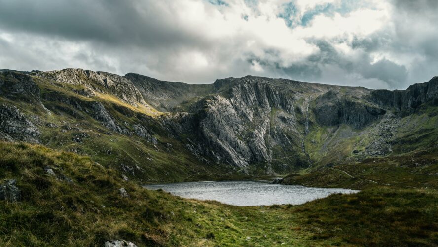 A rocky mountain valley with a lake at the bottom of the valley in Wales.
