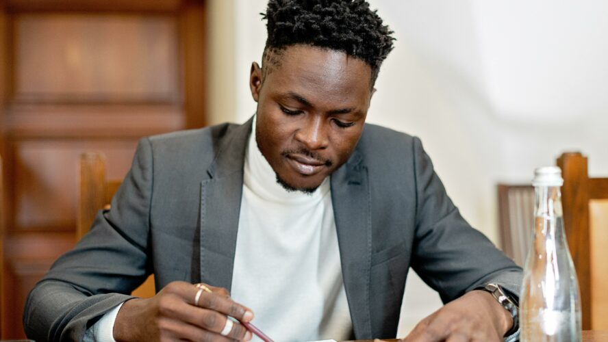 A smart man dressed in a suit reading an important document.
