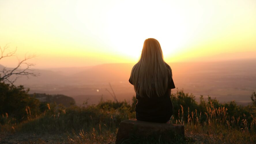 silhouette of woman watching sunset