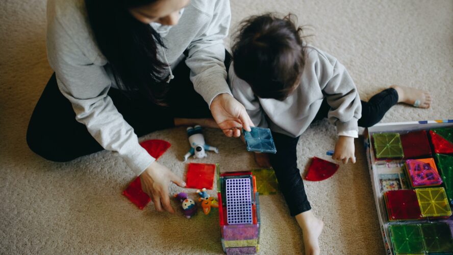 Child playing on floor with a young mother