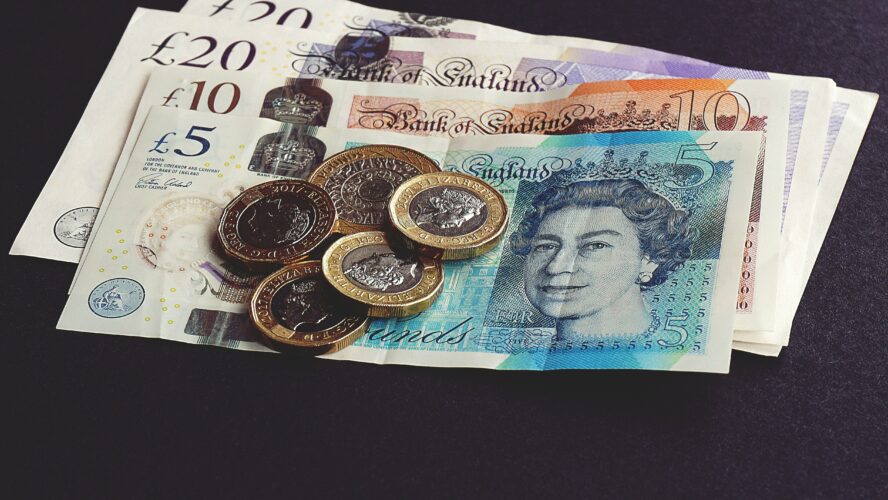 A pile of money including notes and coins.
