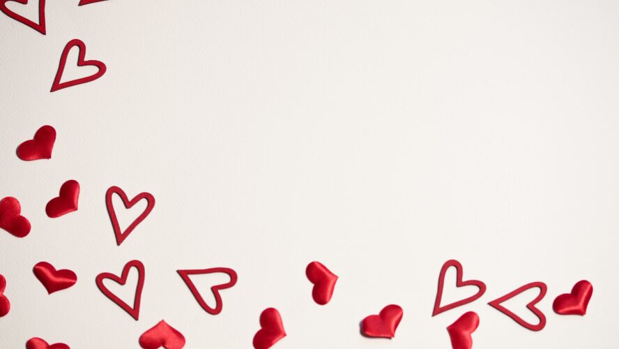 Scattered red hearts on a beige background