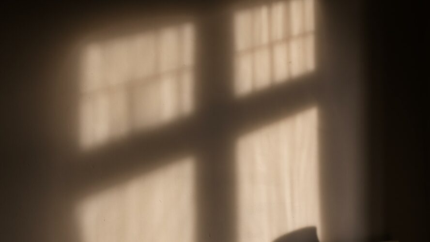 Radiator, blanket and a silhouette of a window on a wall