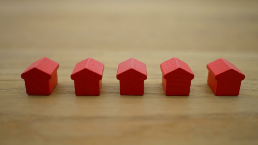 Five red plastic houses in a line