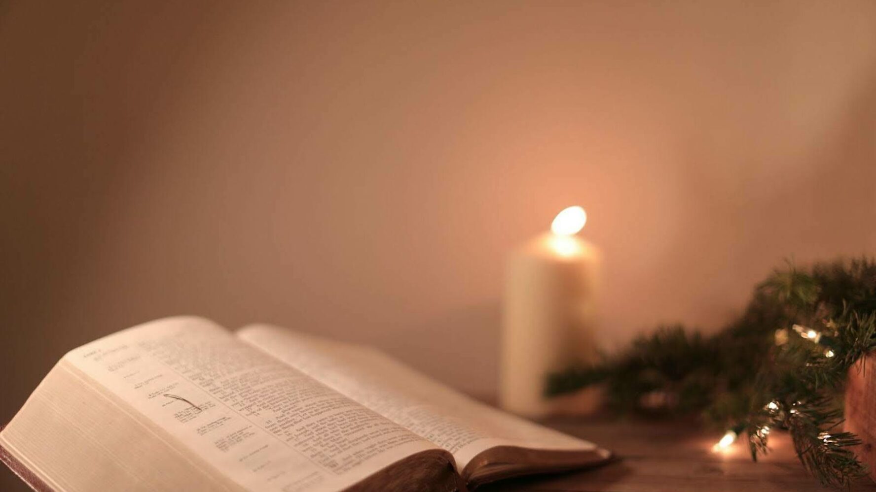 Image showing a bible opened with a candle in the background.