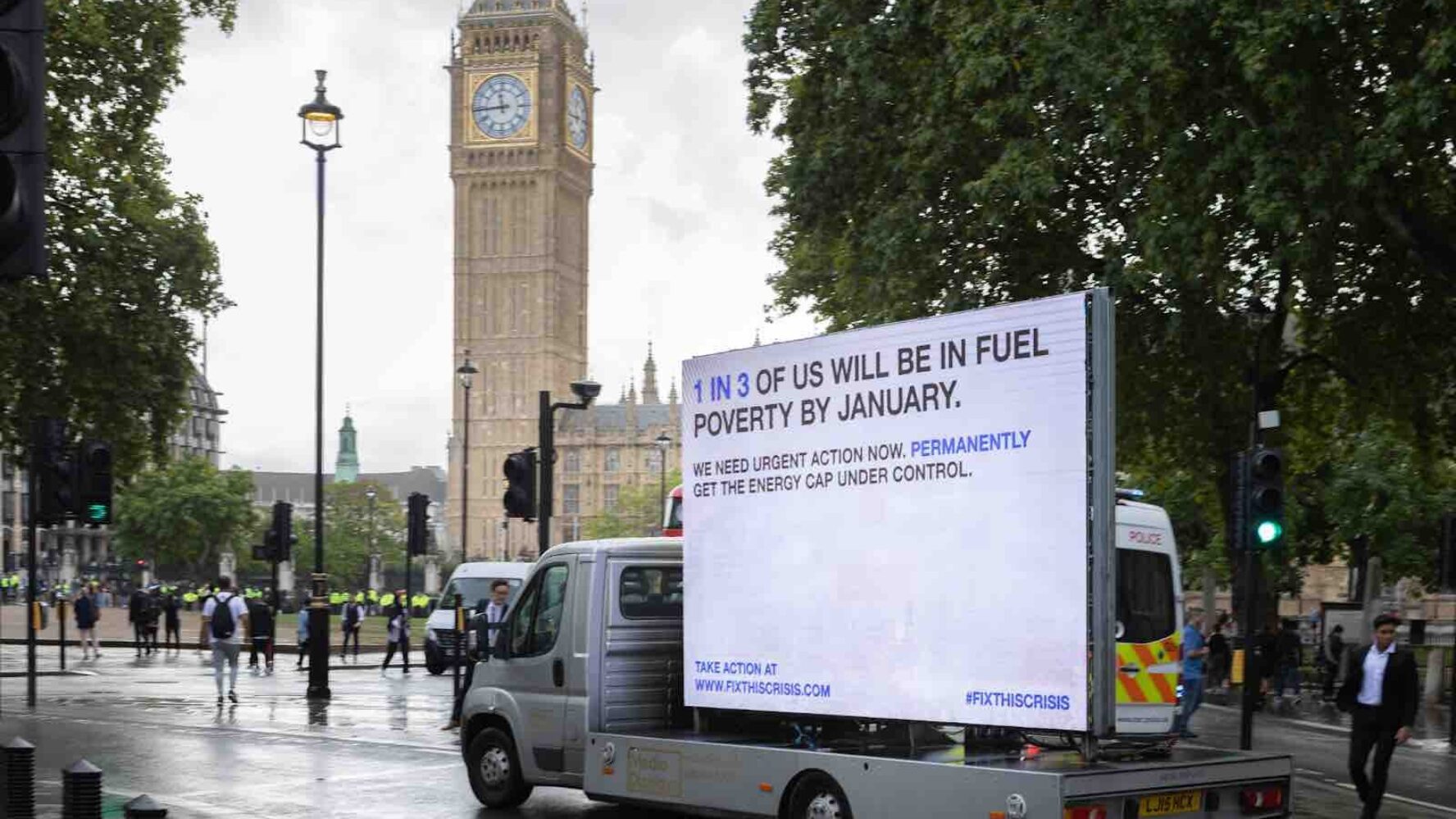 A mobile billboard on a van driving past the Houses of Parliament that says '1 in 3 of us will be in fuel poverty by January'