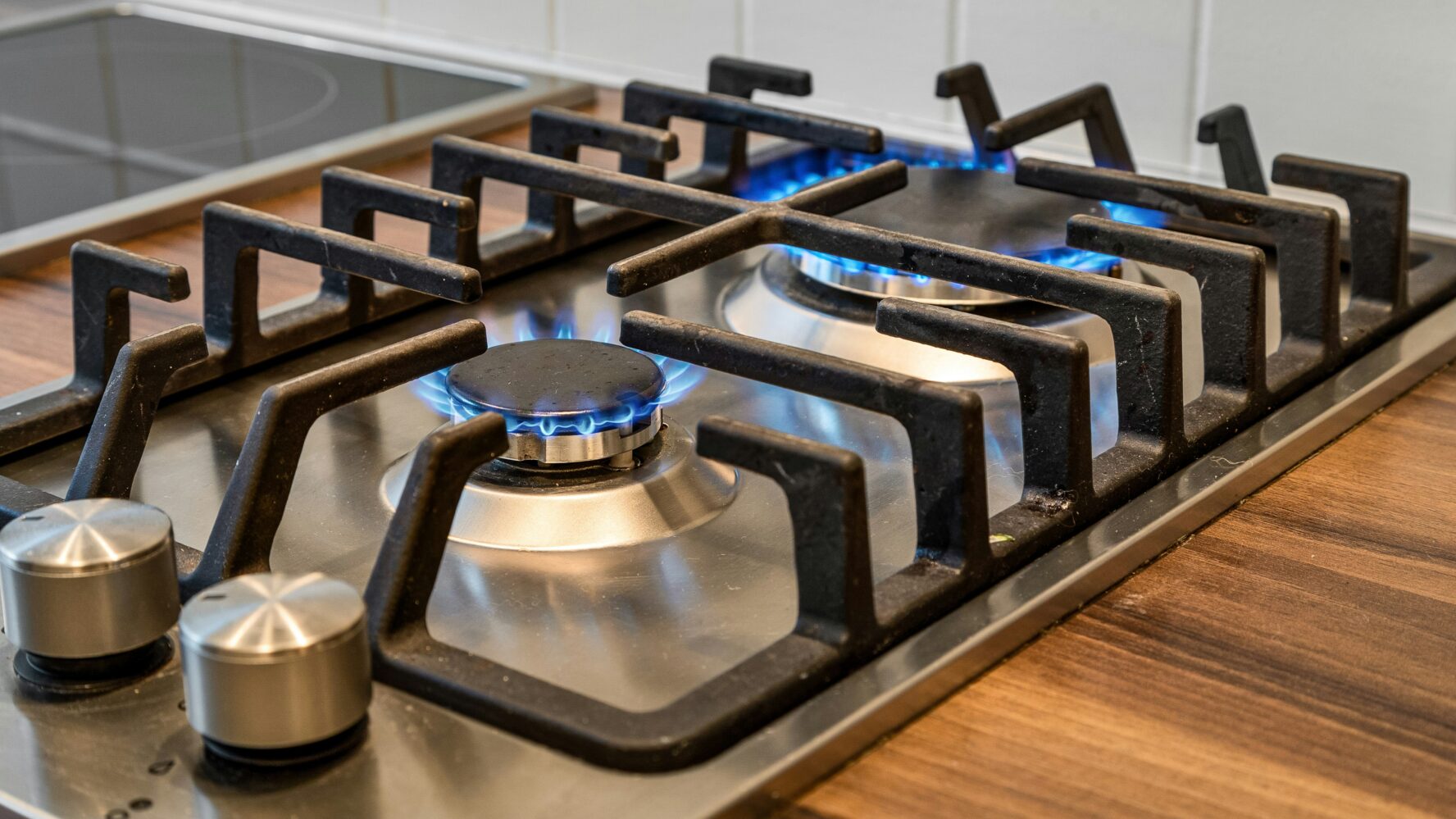 A close-up image of two gas hobs in the kitchen, turned on.