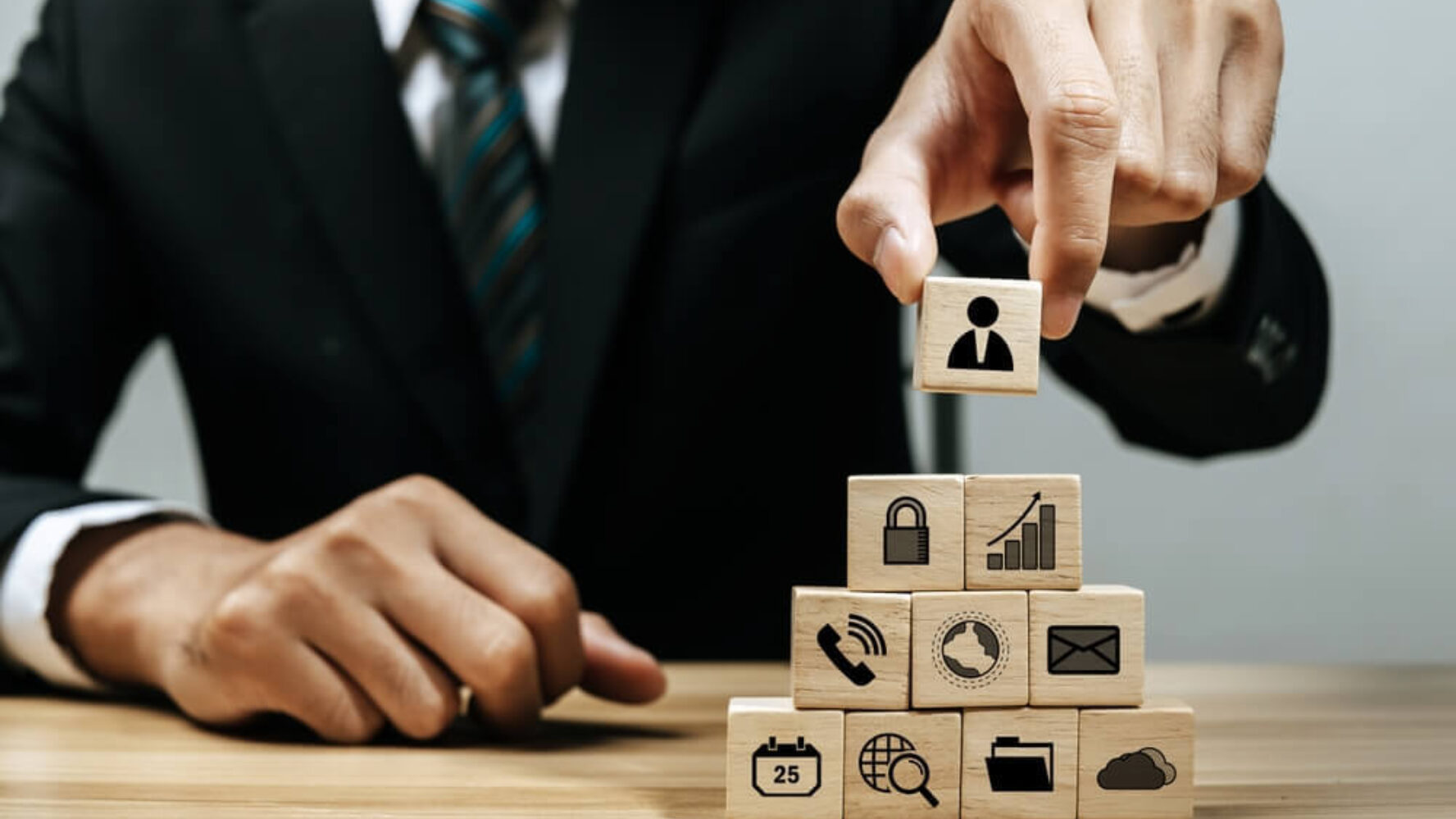 Man in suit building blocks