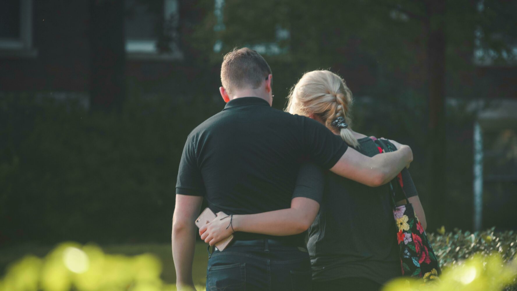 a couple walking away and holding each other