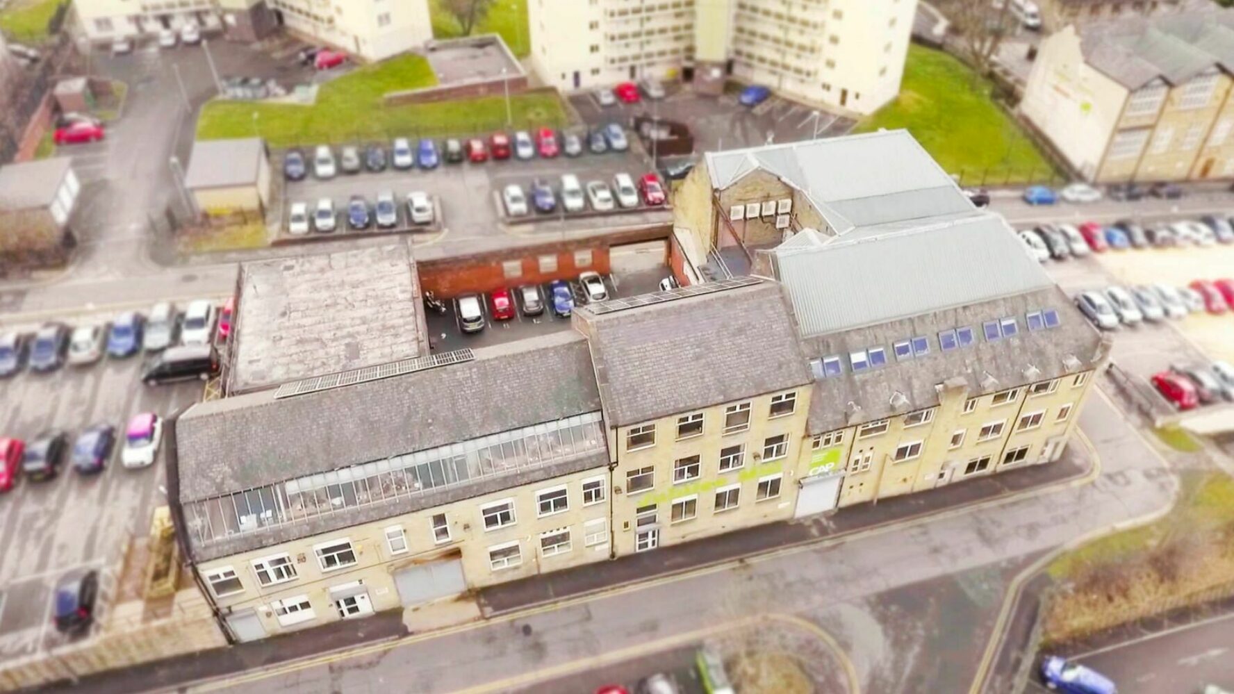 Bird's eye view of the old office building, carpark spaces surrounding it.