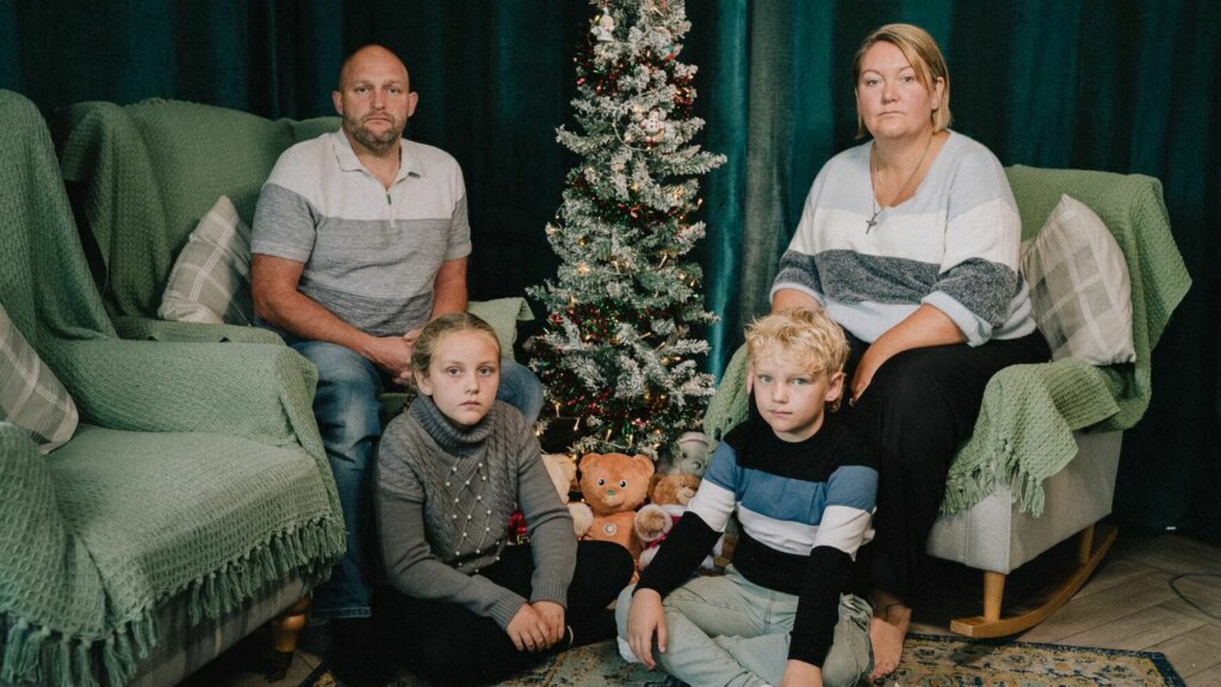 Two CAP clients and their two children sat in their living room at Christmas