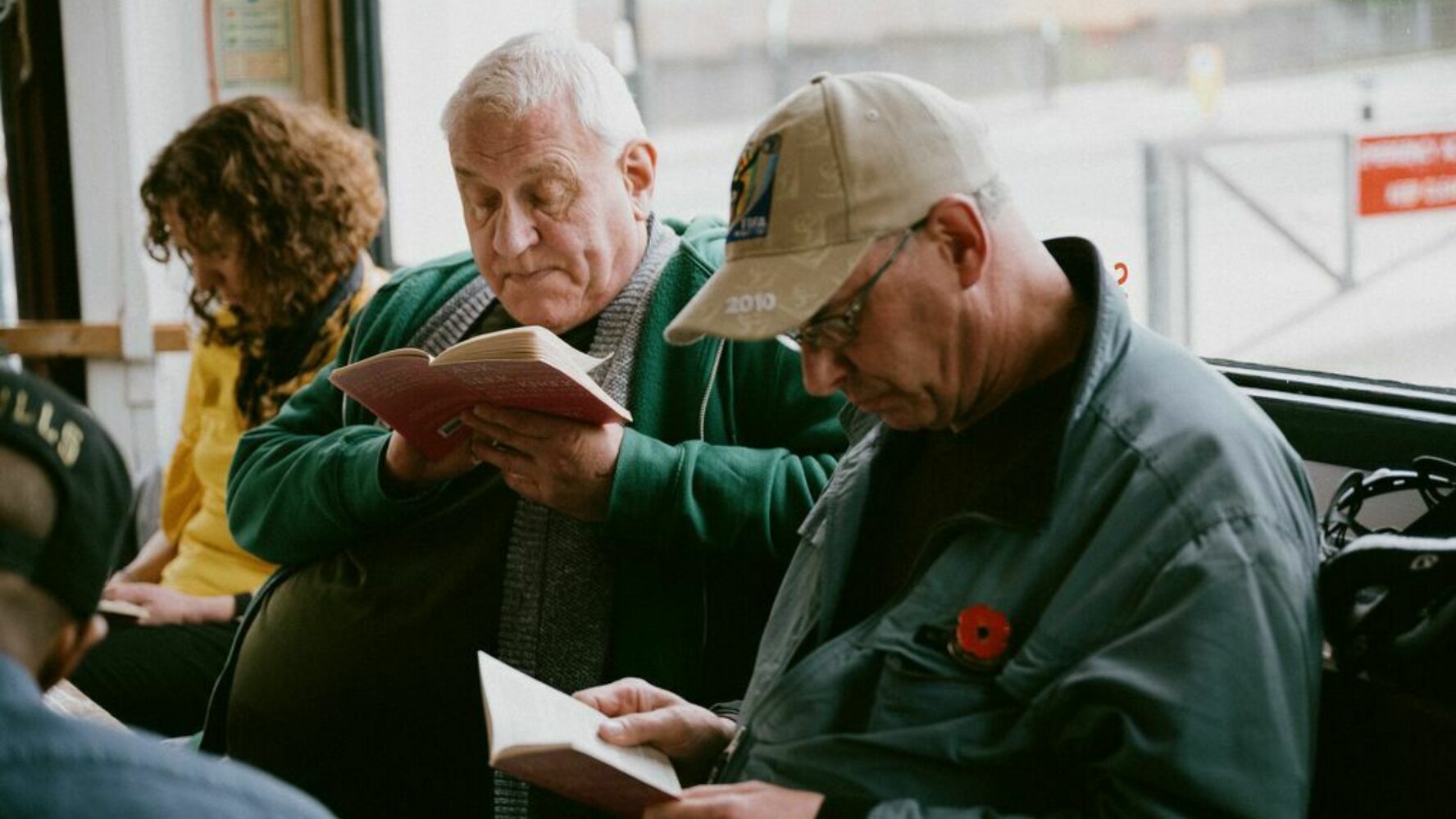 Image showing two older men reading a book in a cafe