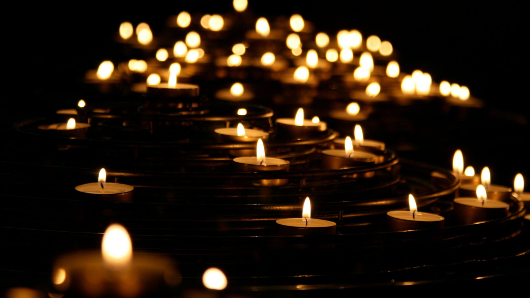 Lots of tealight candles lit on a stand