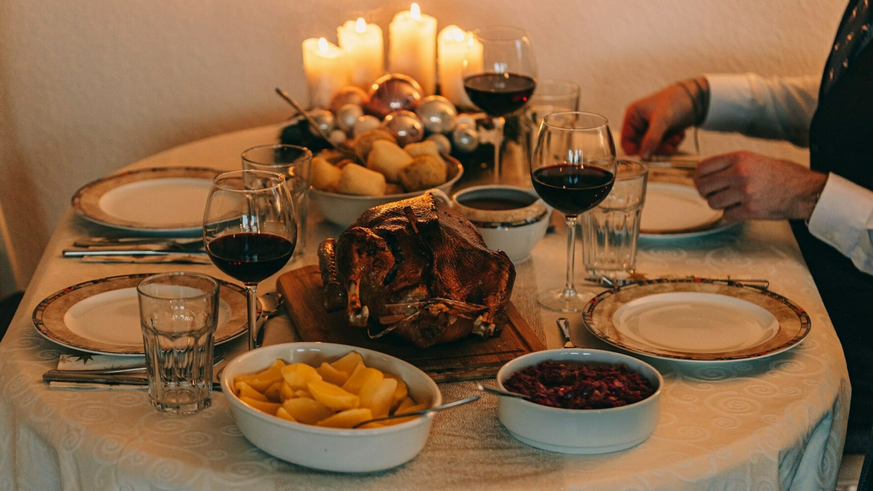 Image showing a table set for Christmas day, with a turkey in the middle and candles in the background