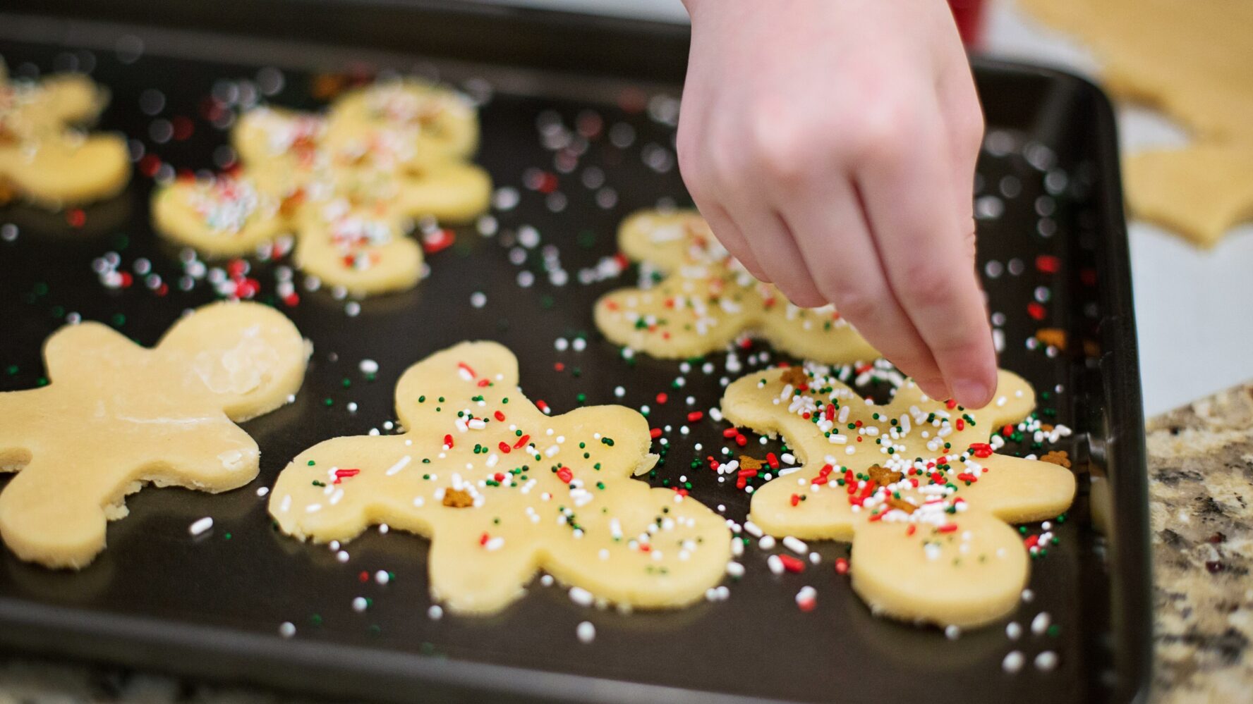 Homemade gingerbread men covered with colourful sprinkles