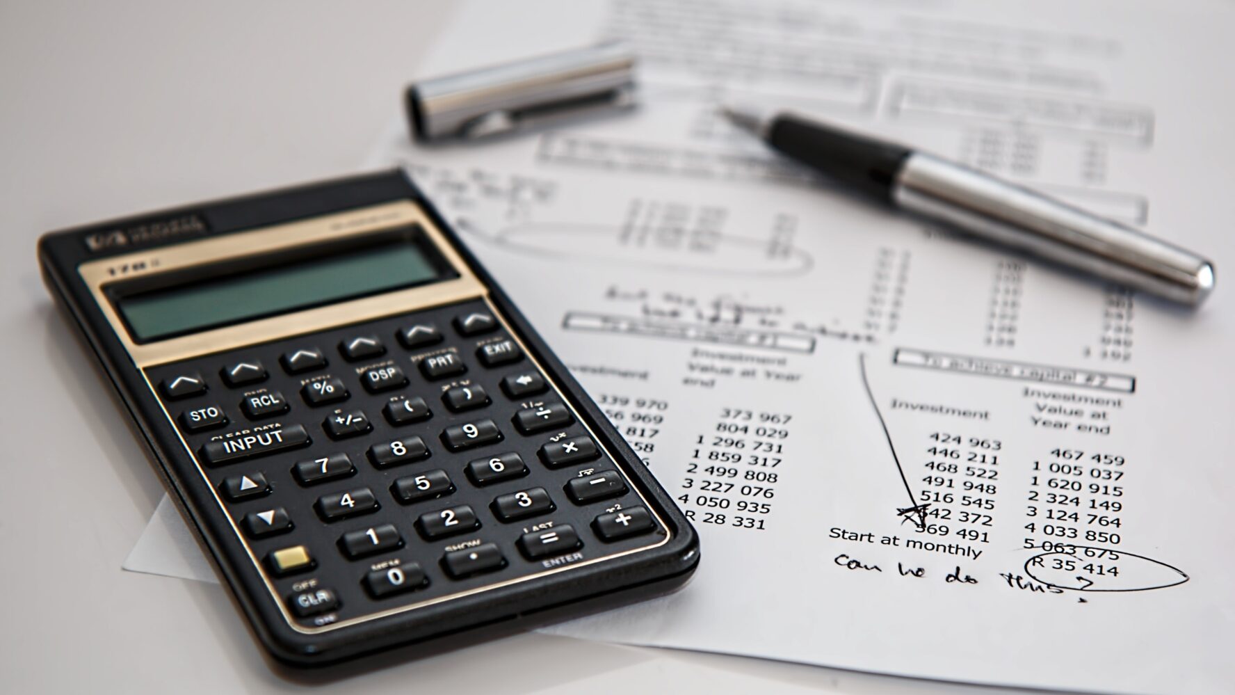 A calculator, pen and budget document.