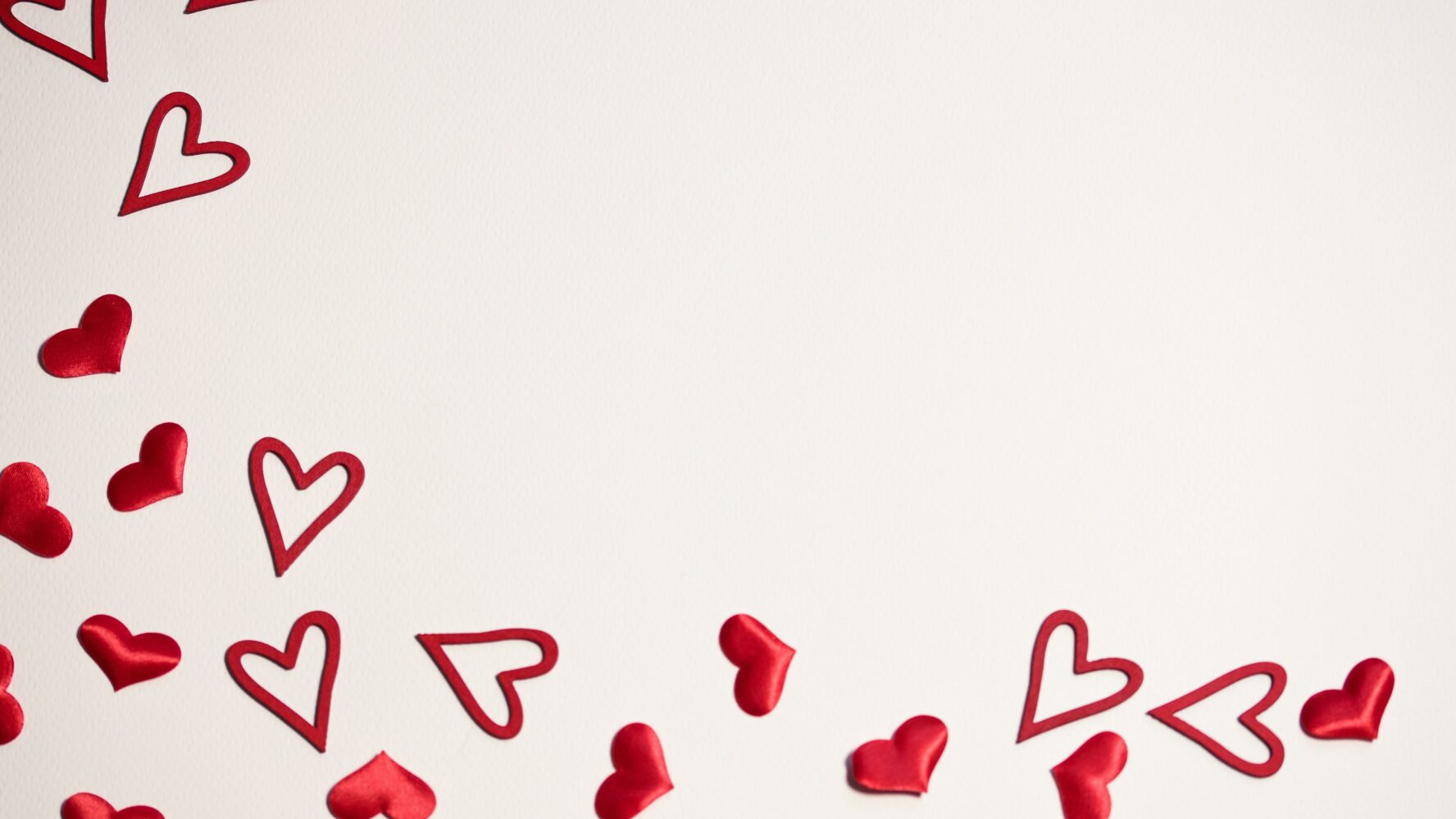 Scattered red hearts on a beige background